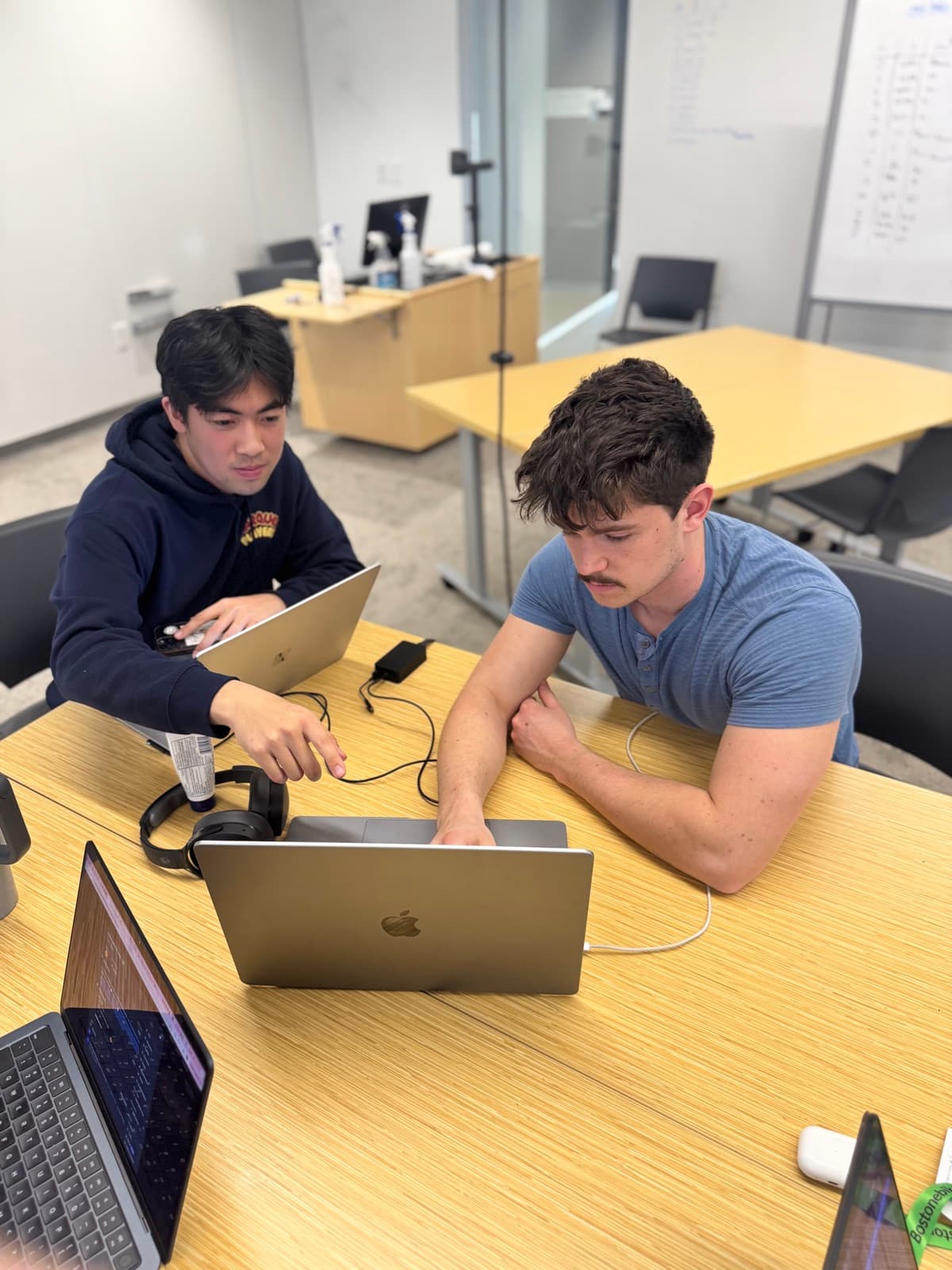 Judson and a teammate working through a problem on a laptop